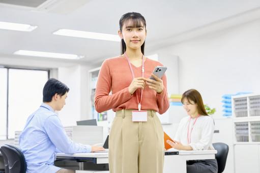 オフィスでスマホを持つビジネスウーマン 女性,スマホ,オフィスの写真素材