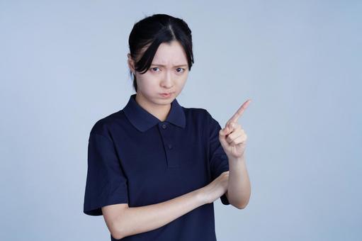 紺色の服の女性が人差し指を立てるの写真