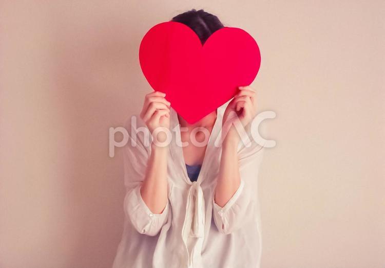 ハートで顔を隠す女性 ハート,女性,顔の写真素材