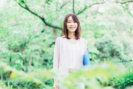 書類を持って歩く若いビジネスウーマン 書類を持って歩く若いビジネスウーマン 外回り,キャリア,資料の写真素材