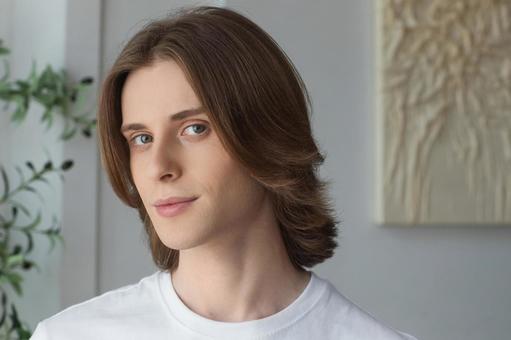 カメラ目線の白いTシャツの長髪の男性 男性,外国人,欧米人の写真素材