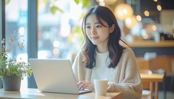 カフェでノートパソコンを使う日本人女性の写真