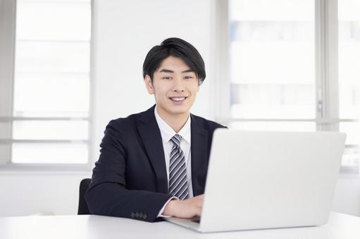 Japanese male businessman wearing a suit and teleworking at home with a smile, telework, home, businessman, JPG