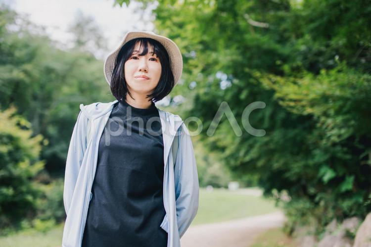 笑顔で森の中を歩く女性　登山 散歩,旅行,散策の写真素材