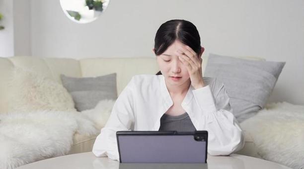 ニュースを見て心配になるアジア人女性 ニュース,心配,女性の写真素材