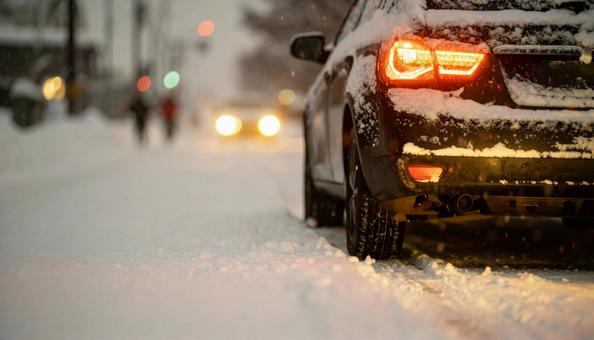 大雪が降った翌日の雪が積もった道を走る車 大雪が降った翌日の雪が積もった道を走る車の写真