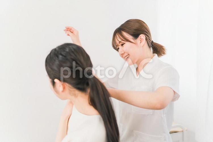 肩甲骨・腕の施術をする理学療法士の女性 腕,肩甲骨,マッサージの写真素材