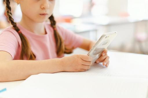 携帯を見る女の子 鼻から下,女の子,子どもの写真素材
