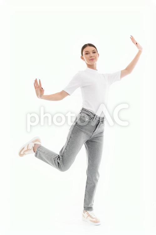 カメラ目線で片足をあげポーズする女性 女性,微笑む,ポーズの写真素材