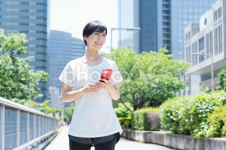 オフィス街をジョギングする若い女性 ランニング,ジョギング,フィットネスの写真素材
