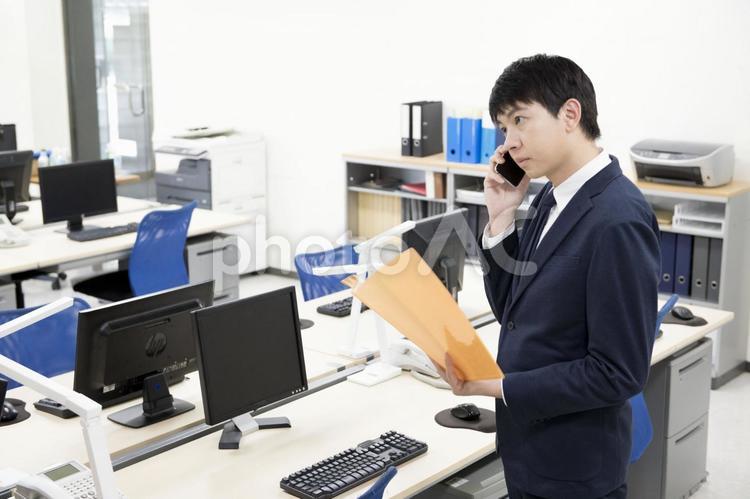 仕事中の男性 オフィス,仕事中,電話中の写真素材