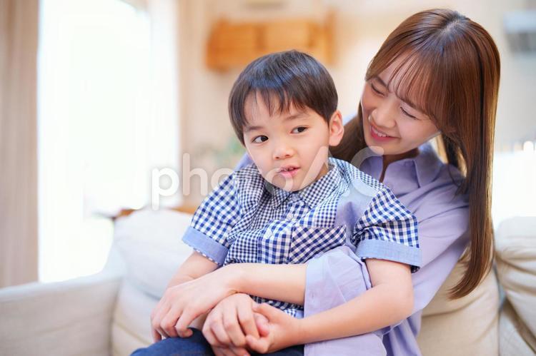 ソファーで母の膝に座る男の子 親子,母,息子の写真素材