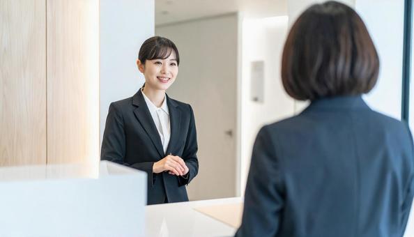 会社の受付で働く笑顔の女性社員 会社の受付で働く笑顔の女性社員の写真