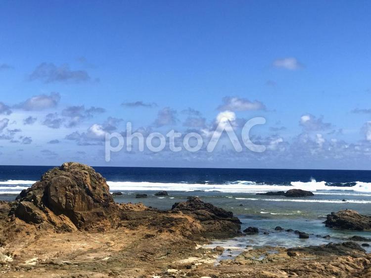 抜けるような青空を背景に映える波に洗われた赤茶けた大岩 風景,浜辺,夏の写真素材