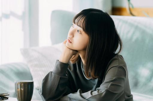 リビングで考えごとをする女性 女性,考える,考えごとの写真素材