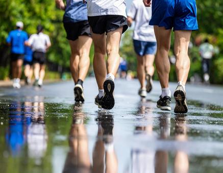 濡れた路面を走るランナー 濡れた路面を走るランナーの写真