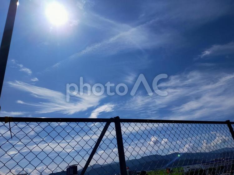 太陽と青空とフェンス 空背景,ブルー,空の写真素材