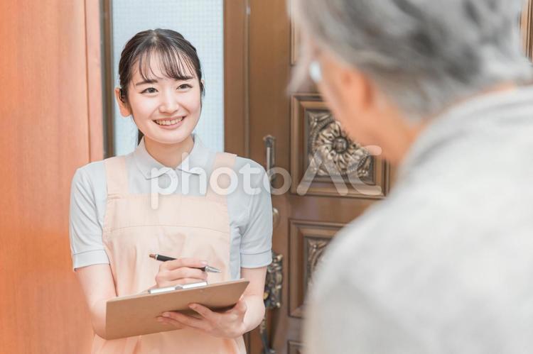 高齢者住宅に訪問する女性（書類） 民生委員,見守り,カウンセリングの写真素材