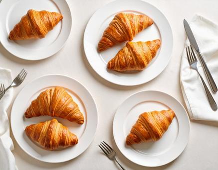 机の上のたくさんんのクロワッサンの写真