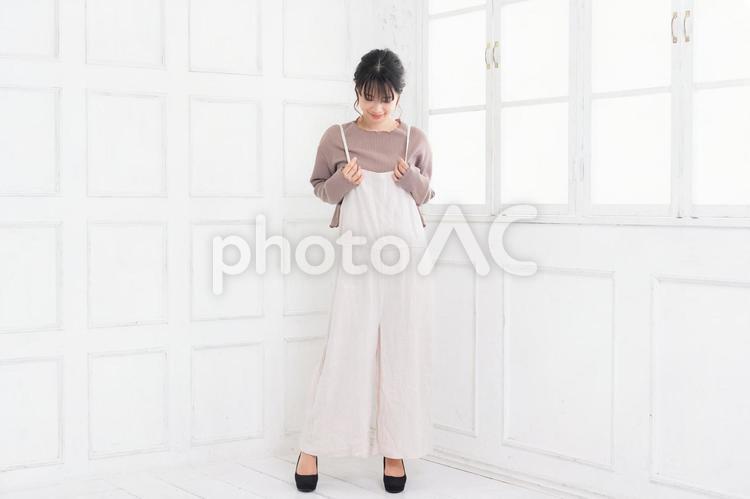 白い部屋に立ってポーズをとる若い女性 女性,立つ,ポートレートの写真素材