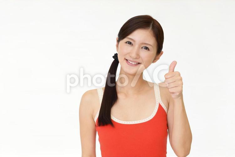いいねのポーズをとるタンクトップ姿の女性 女性,笑顔,タンクトップの写真素材