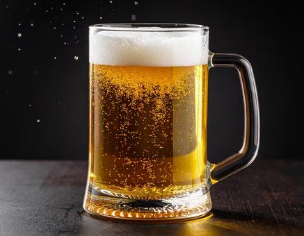 黒背景に冷えたビールのジョッキ 黒背景に冷えたビールのジョッキの写真