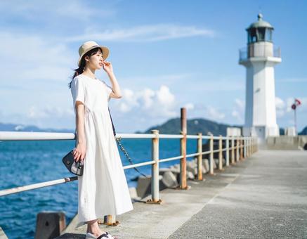 夏の灯台と海辺散歩の写真