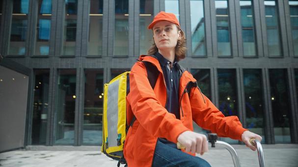 自転車で配達する男性配達員の写真