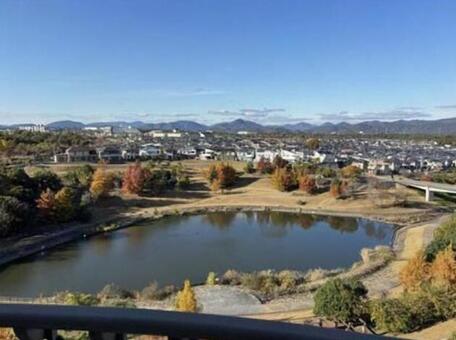高台から望む、郊外の秋景 紅葉,青空,山並みの写真素材