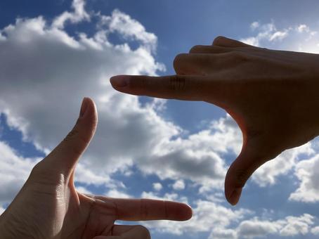 指フレームで空を切り取る構図 指,空,雲の写真素材