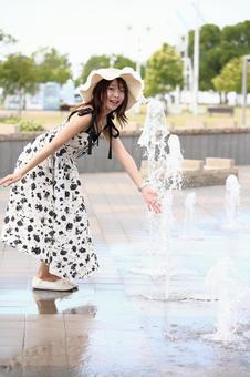 公園の噴水で遊ぶ女性 公園の噴水で遊ぶ女性の写真
