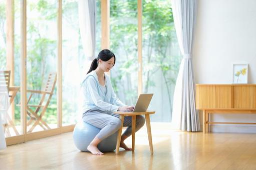 バランスボールに座りパソコン中の女性 女性,バランスボール,ノートパソコンの写真素材