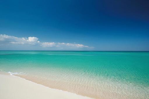 夏の快晴の青空とエメラルドグリーンの海の写真