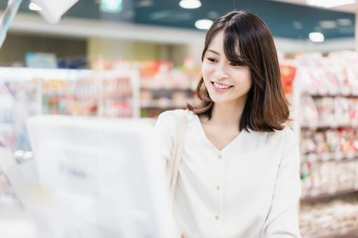スーパーでスマホ決済を使う若い女性 消費者,小売り,支払の写真素材