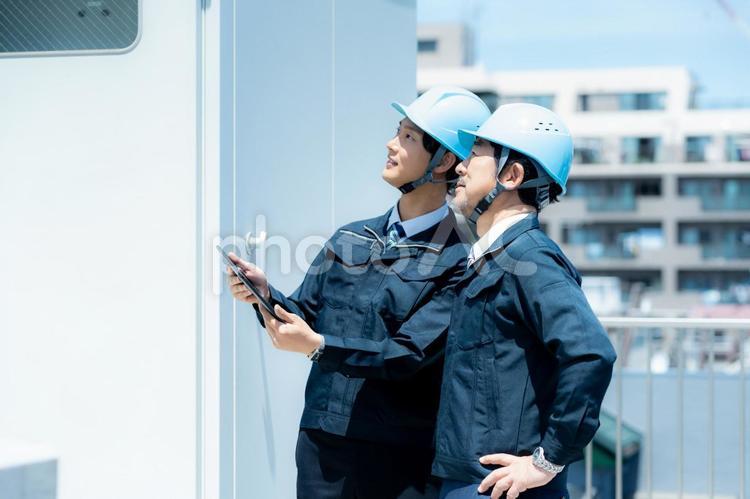 現場で打ち合わせする作業服のビジネスマン 作業服,笑顔,打ち合わせの写真素材