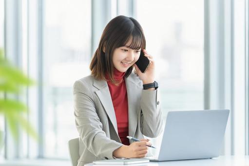 デスクワークをする女性・ビジネスウーマン 女性,スマホ,スマートフォンの写真素材