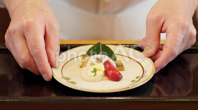料理を差し出す料理人の手元 料理,差し出す,料理人の写真素材