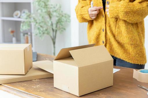 荷造りする女性の手元 荷造りする女性の手元 段ボール,荷造り,ガムテープの写真素材