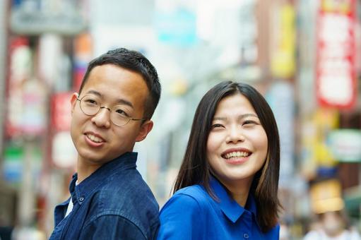 笑顔で背中合わせに立つ若いカップル 笑顔で背中合わせに立つ若いカップル カップル,散歩,恋人の写真素材