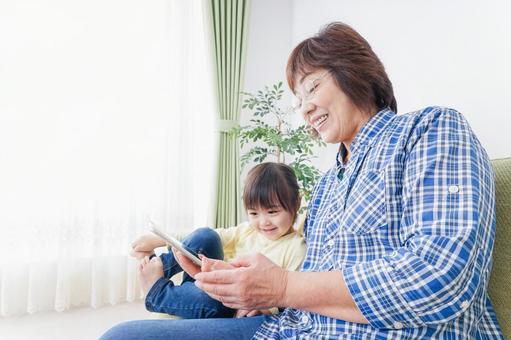 おばあちゃんとスマホを使う子供 おばあちゃんとスマホを使う子供 携帯電話,おばあちゃん,日本人の写真素材
