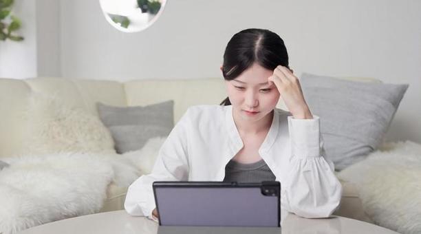 ニュースを見て心配になるアジア人女性 ニュース,心配,女性の写真素材