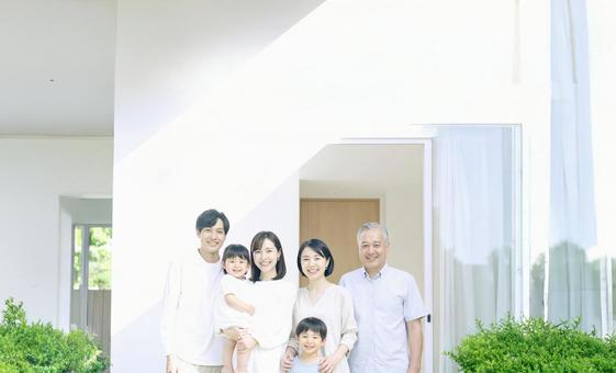 マイホームの前で撮影する三世代家族 マイホームの前で撮影する三世代家族の写真