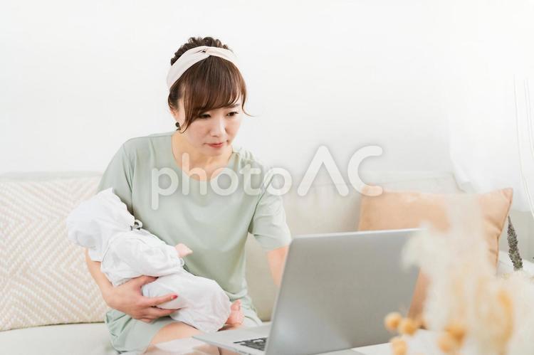 赤ちゃんを抱きながら在宅ワークする女性 赤ちゃん,育児,ママの写真素材