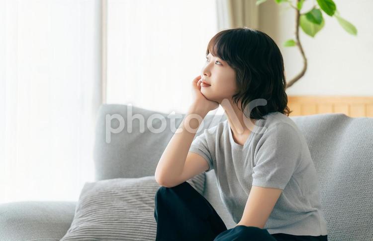 リビングのソファに座る笑顔の女性 女性,ソファ,微笑むの写真素材