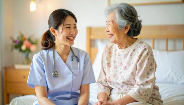 笑顔で話をする女性介護士と高齢女性の写真