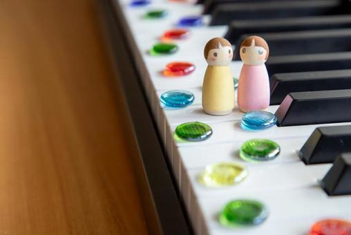 Marbles and small dolls lined up on the piano keys, JPG Marbles and small dolls lined up on the piano keys, JPG
