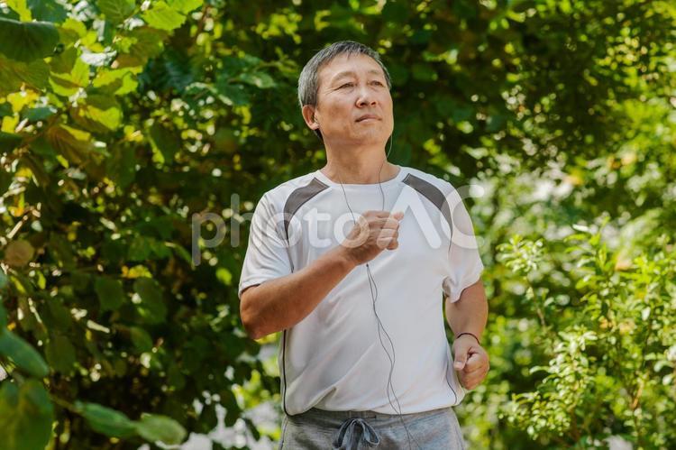 音楽を聴きながら走っているアジア人シニア男性 シニア,スポーツ,男性の写真素材