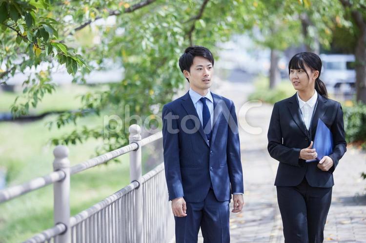 スーツで談笑しながら歩くビジネスマン　 ビジネス,スーツ,男女の写真素材