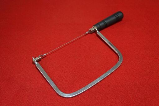 赤背景に置かれた糸鋸 糸のこ,道具,工具の写真素材