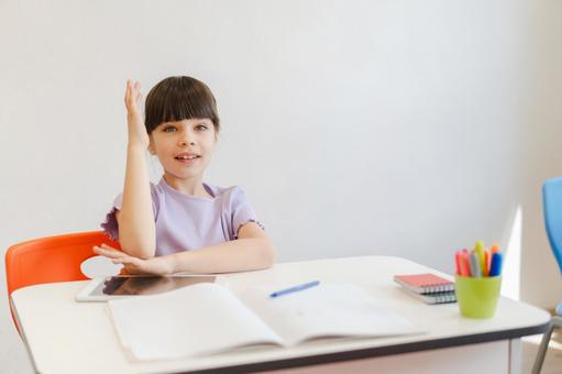カメラ目線で肘をつけて手を挙げる女の子 男の子,子ども,人物の写真素材